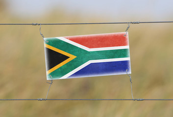 Border fence - Old plastic sign with a flag