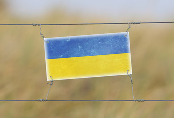 Border fence - Old plastic sign with a flag