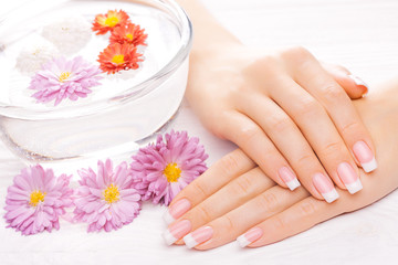 beautiful french manicure on white wooden table