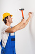 © Friends Stock - Smiling repairman nailing