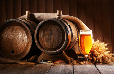 Wall Mural - Beer barrel with beer glass on table on wooden background