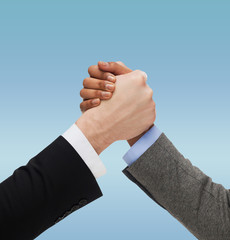 close up of two hands multiracial armwrestling