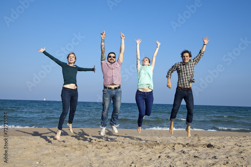 Fotografie, Obraz Amigos saltando sobre la arena de la playa