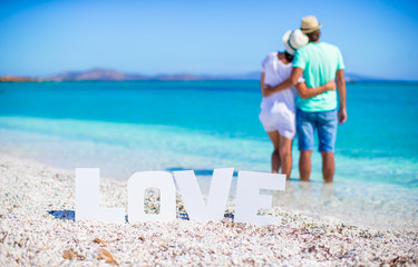 Wall Mural - Young happy couple on white beach during summer vacation