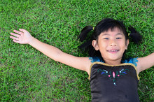 Asian Girl Lying On Grass Hand Rise Her Hand.