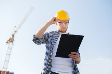 Canvas Print - builder in hardhat with clipboard outdoors