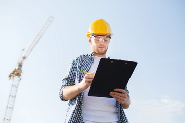 Canvas Print - builder in hardhat with clipboard outdoors