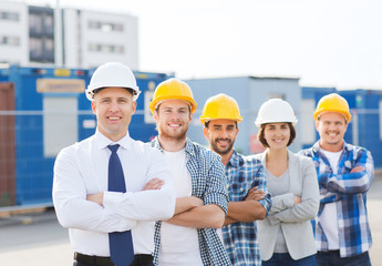 Canvas Print - group of smiling builders in hardhats outdoors