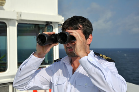 Fototapete - navigator on navigation bridge during his watch  with binocular
