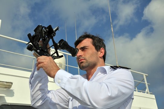 Fototapete - navigator with sextant on the watch on sea going vessel