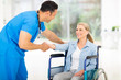 © michaeljung - mid age medical doctor greeting disabled patient
