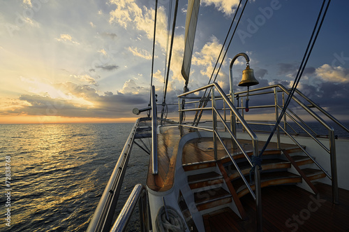 Fototapeta na wymiar Yacht Sailing against sunset. Sailboat. Sailing
