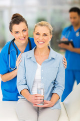 senior woman in doctor's office with young nurse