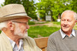 © Robert Kneschke - Zwei Senioren reden auf Bank im Pflegeheim miteinander