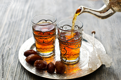 Fényképezés Traditional arabic tea with dates and sugar on a plate