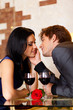 © mast3r - Young happy couple romantic kissing date with glass of red wine