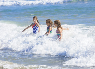 Kids playing in the ocean surf on vacation