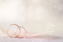 Two Golden Wedding Rings And Feather - Light Soft Background