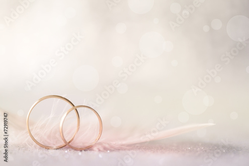 Fotografía Two Golden Wedding Rings and Feather - light soft background