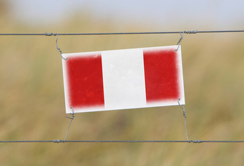 Border fence - Old plastic sign with a flag