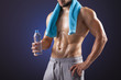 © cristovao31 - Fitness man holding a bottle of fresh water on black background