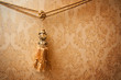 Beautiful golden tassel hanging on a rope on the background