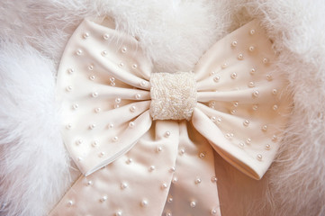 Color ivory bow against a white coat