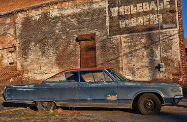 Old car and typo in a downtown industrial area that has long since been abandoned by business