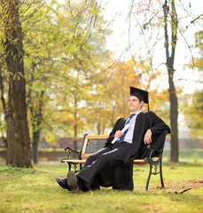 Canvas Print - Graduate student holding diploma in park