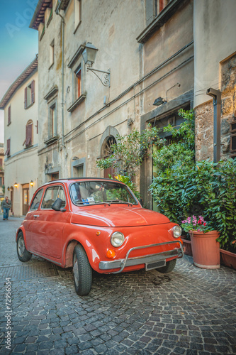 Naklejka dekoracyjna Old vintage cult car parked on the street by the restaurant, in