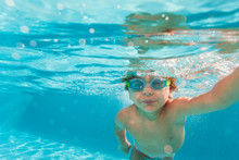 Small Boy Swimming Wearing Goggles Under Water