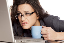 Sleepy And Tired Business Woman On Laptop, Holding A Coffee Mug