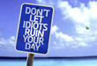Don't Let Idiots Ruin Your Day sign with a beach on background