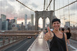 Happy Young Woman on Brooklyn Bridge showing Thumbs Up