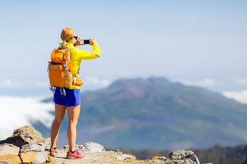 Wall Mural - Woman hiker taking photos  in mountains