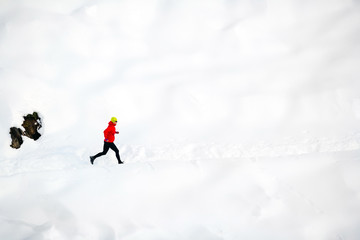 Wall Mural - Woman running on snow in mountains