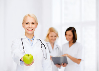 Canvas Print - smiling female doctor with green apple