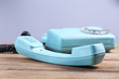 © Africa Studio - Retro turquoise telephone on wooden table, on color background