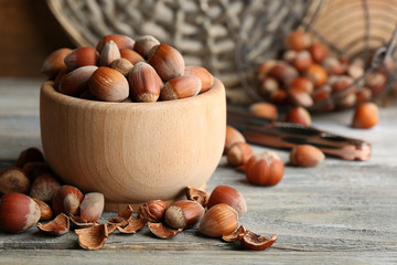 Wall Mural - Hazelnuts in wooden bowl on wooden background