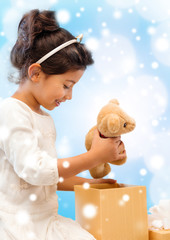 Wall Mural - smiling little girl with gift box and teddy bear