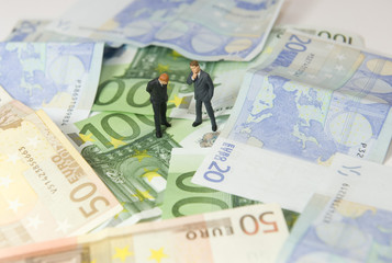 Wall Mural - Hommes discutant sur un tapis de billet en euros