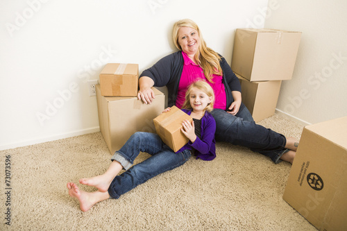 Fotografie, Obraz Young Mother and Daughter In Empty Room With Moving Boxes