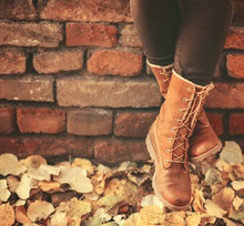 Conceptual Image Of Legs In Boots On The Autumn Leaves - Walking