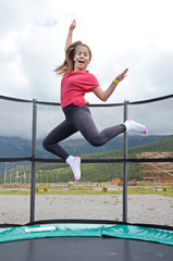 teenage girl jumping on a trampoline