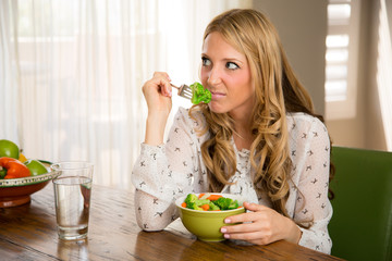 Woman smelling her boring healthy vegan food