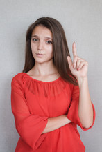 Happy Young Woman Shows An Index Finger Upwards