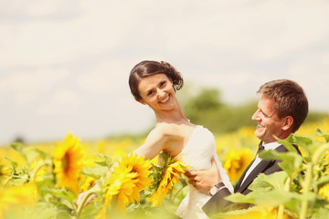 Beautiful couple having fun in sunflowers fields