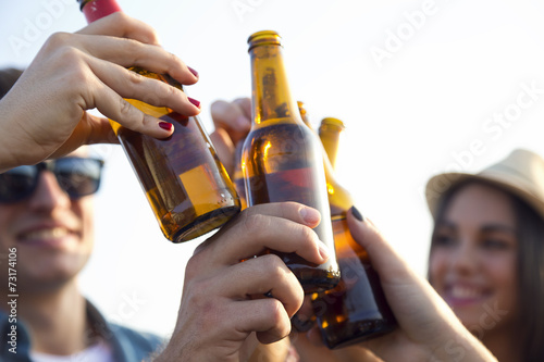 Fotografía Retrato de grupo de amigos que tuestan con botellas de cerveza.