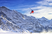 Red Helicopter Flying At Swiss Alps Near Jungfrau Mountain