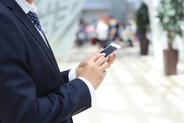 Wall Mural - Close up of a business man using mobile smart phone